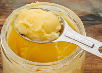 jar and measuring tablespoon of ghee - clarified butter