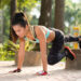 Asian young woman doing plank exercise outdoors
