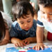 Children reading a book on the floor